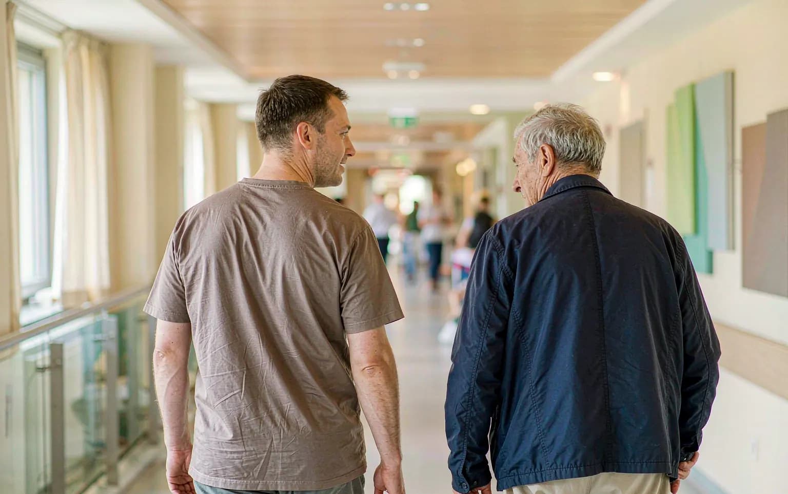 A medical interpreter walking with an international patient through a hospital corridor